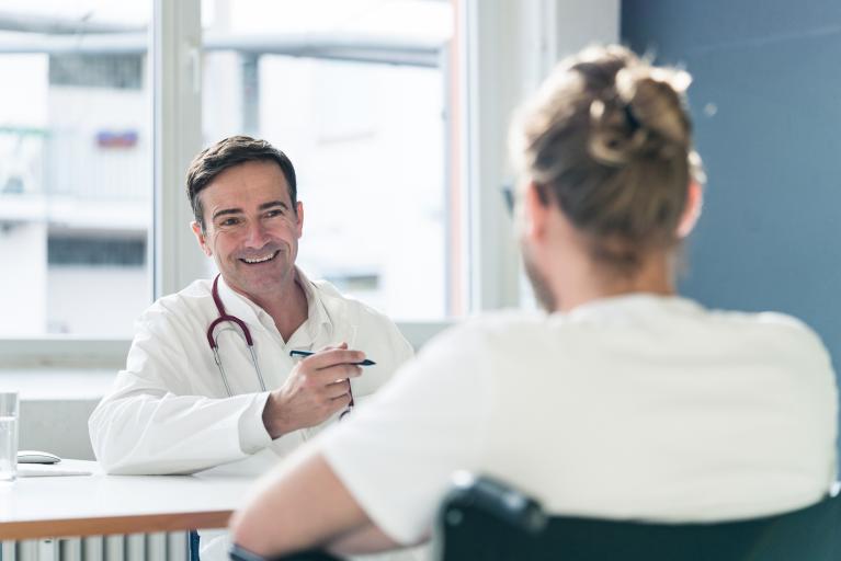 Freundlicher Arzt im Gespräch mit Patient zur Lungenkrebsvorsorge