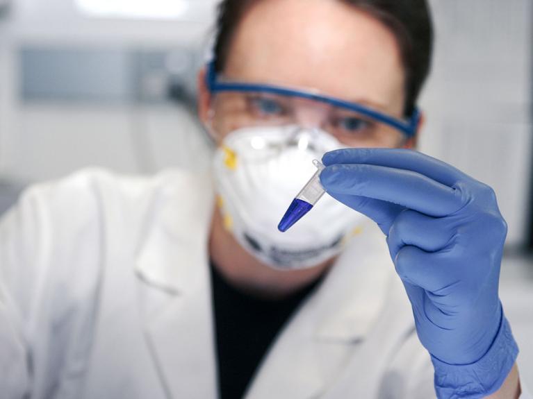 Arzt hält Reagenzglas in der Hand
