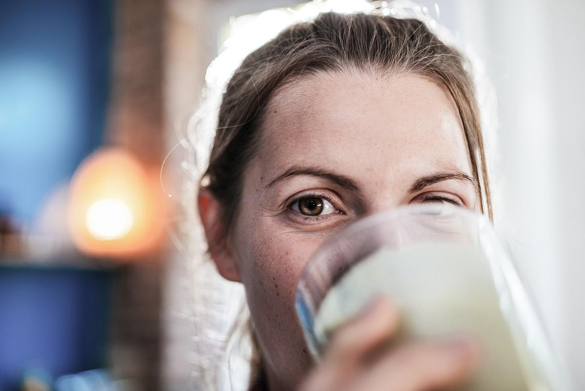 Gutgelaunte Frau trinkt ein Glas Milch