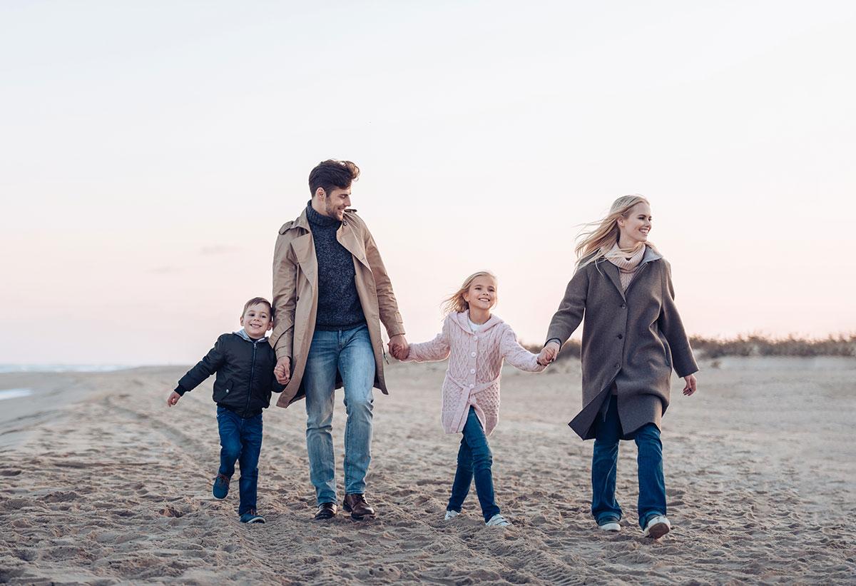 Junge Familie geht am Strand spazieren