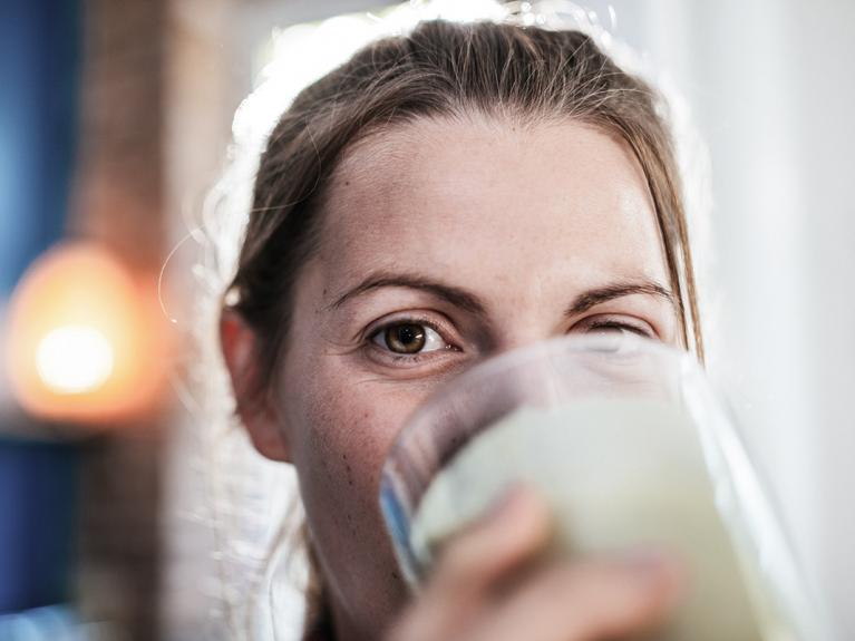 Gutgelaunte Frau trinkt ein Glas Milch