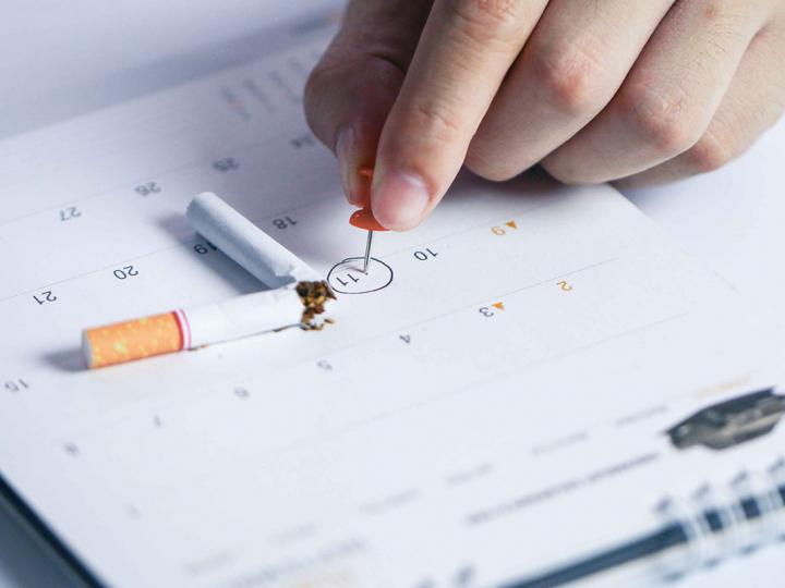 Auf einem Kalender ist ein Datum umkreist und eine zerbrochene Zigarette liegt daneben