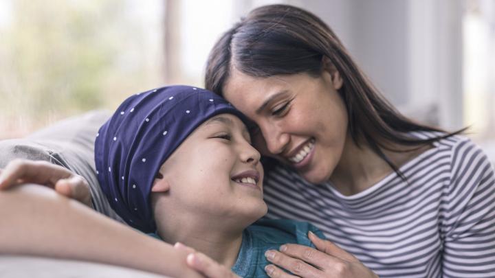 Mutter kuschelt mit ihrer Krebskranken Tochter